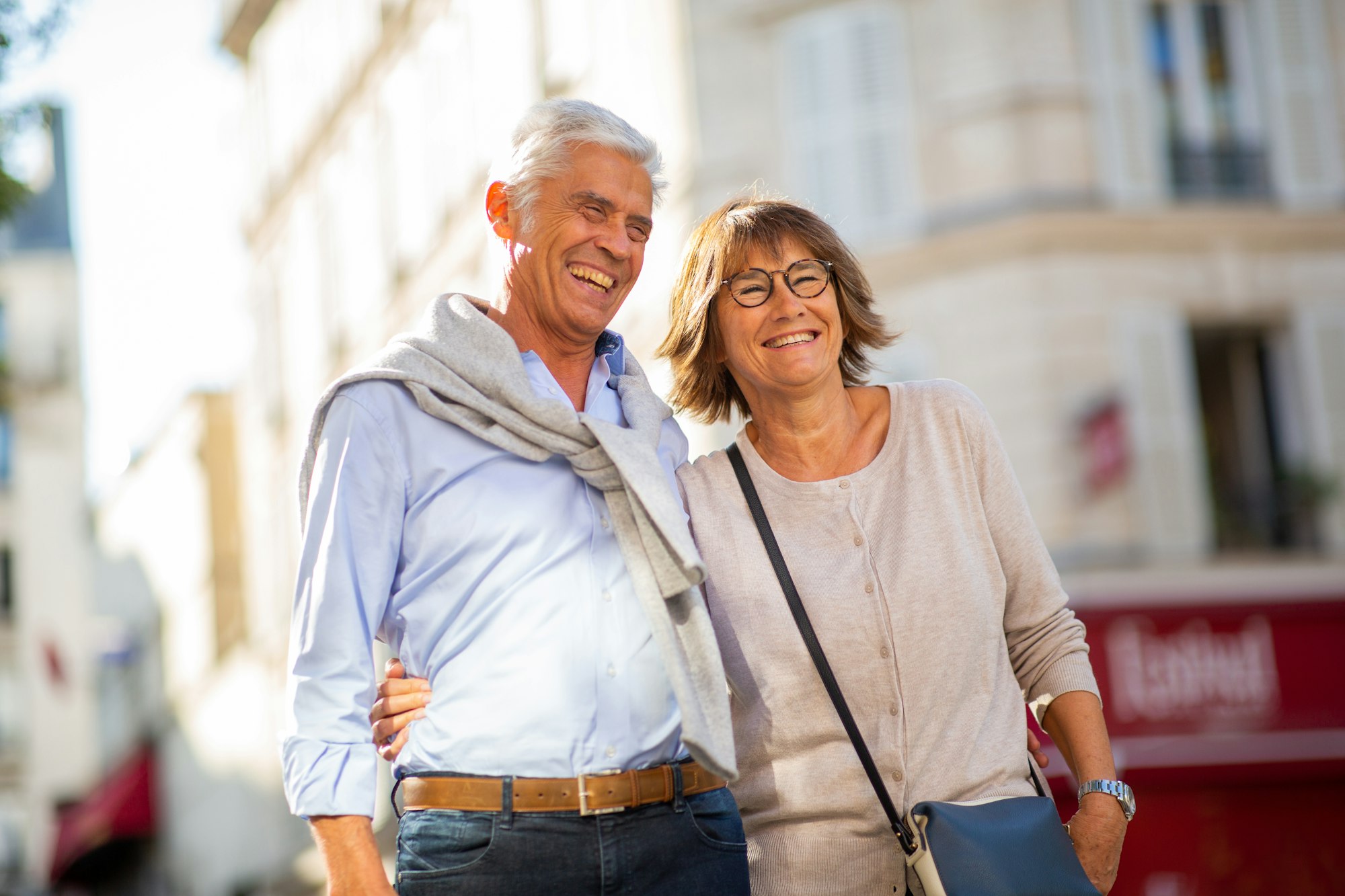 smiling older couple standing outside in city